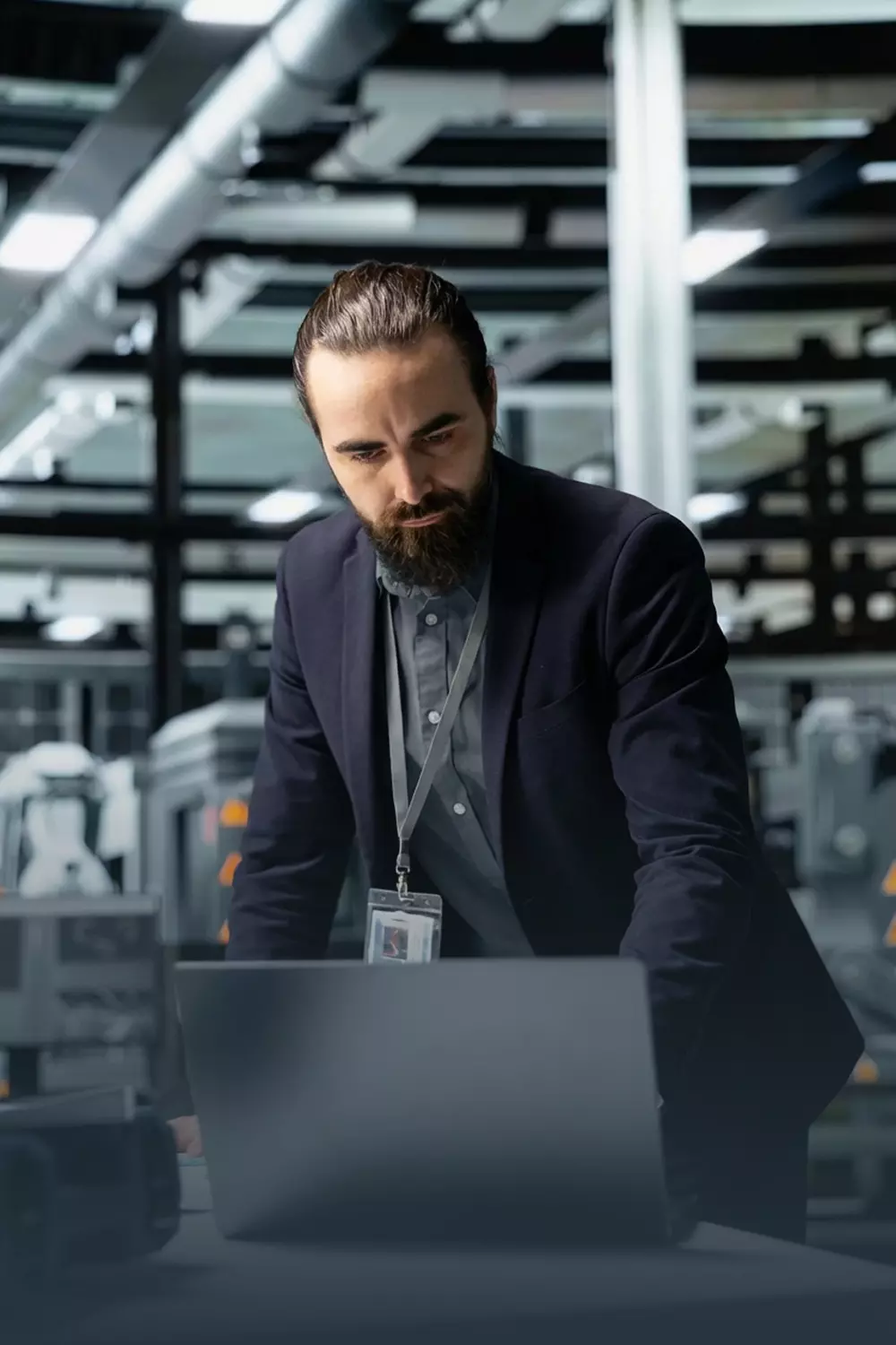 Mężczyzna w ciemnej marynarce z laptopem